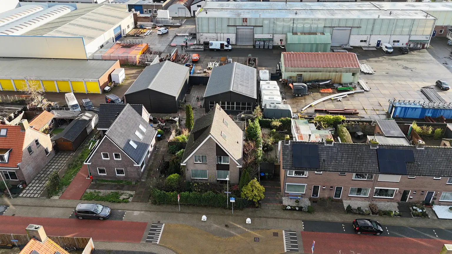 Top view of houses and campervans with photovoltaic panels installed on several rooftops in the neighborhood.