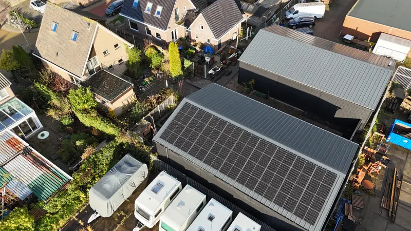 Aerial view of a photovoltaic installation on a house, surrounded by other nearby homes