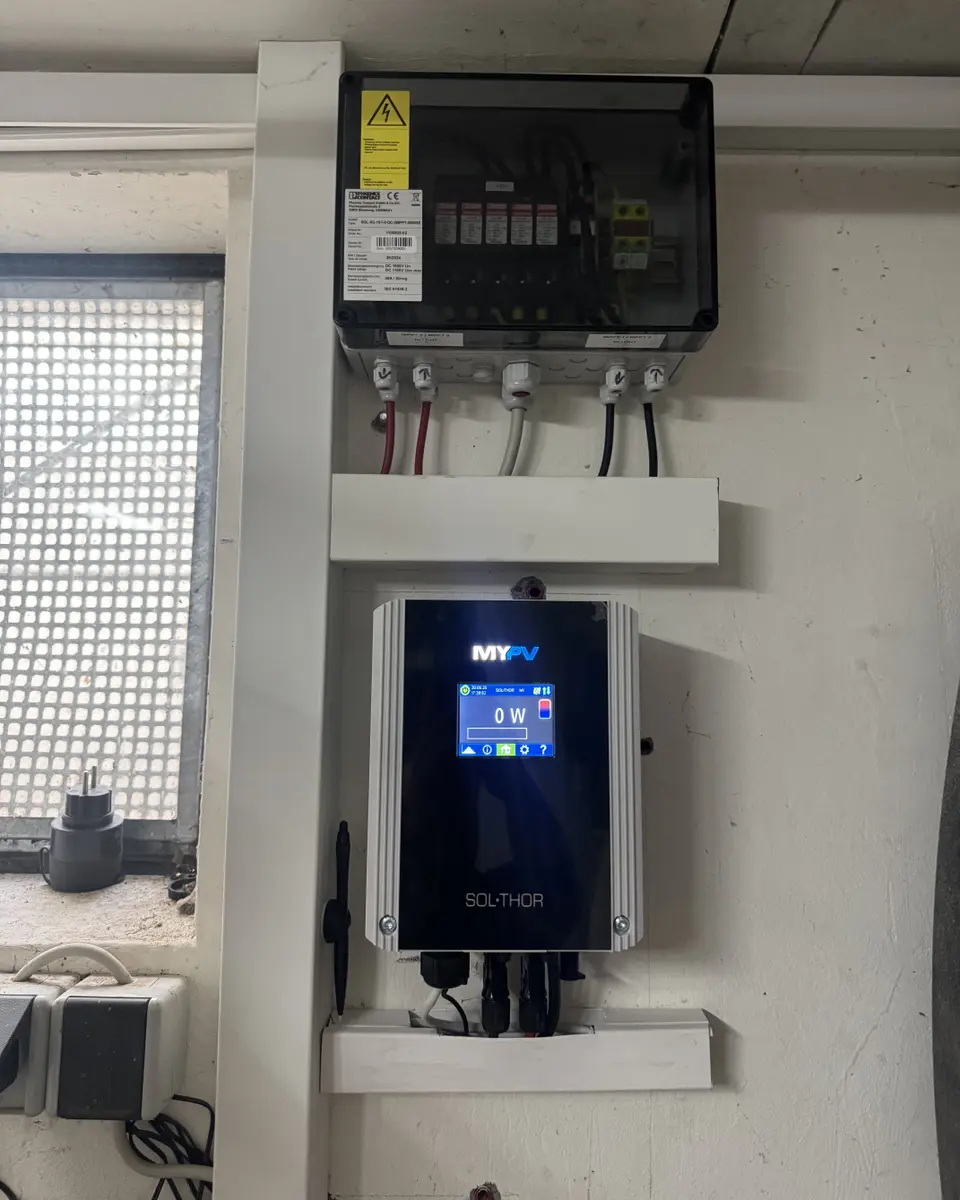 Electric control system with labeled components, wiring connections, and a digital display panel mounted on a white wall.