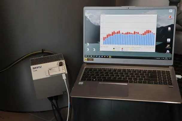Laptop showing a bar graph connected to an ELWA, likely monitoring energy usage, on a gray background