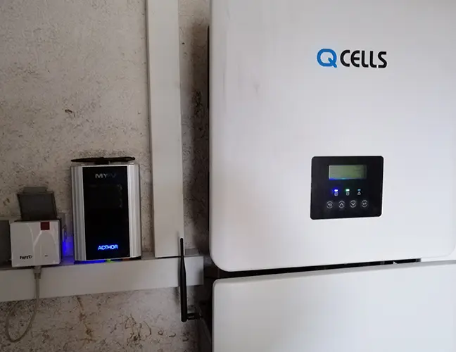 Q CELLS solar inverter and my-PV AC•THOR mounted on a wall with visible wiring.