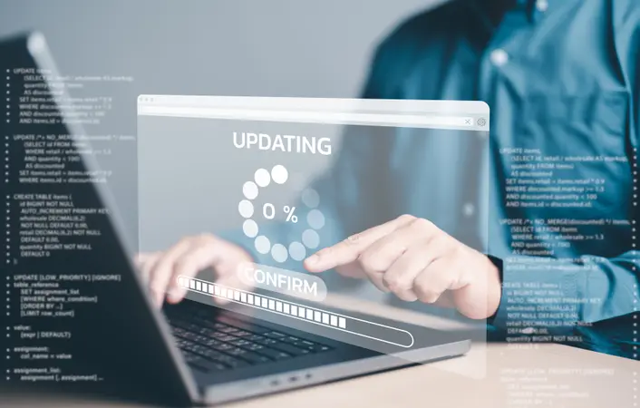 A man wearing a blue shirt working at a computer with a hologram showing an update in progress