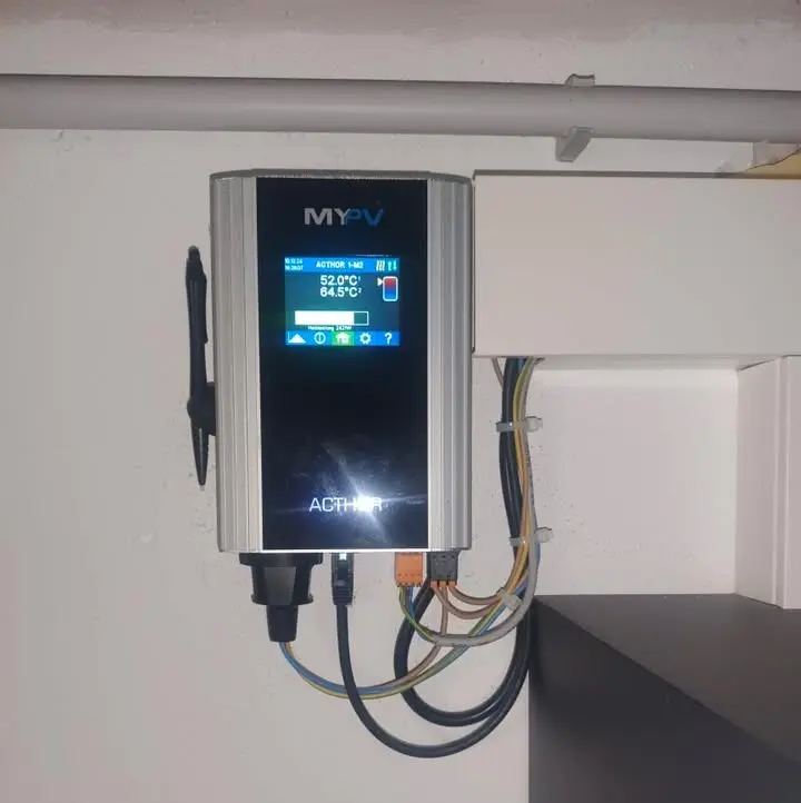 Wall-mounted my-PV AC•THOR control unit with digital display showing temperature and status, connected by colored wires.