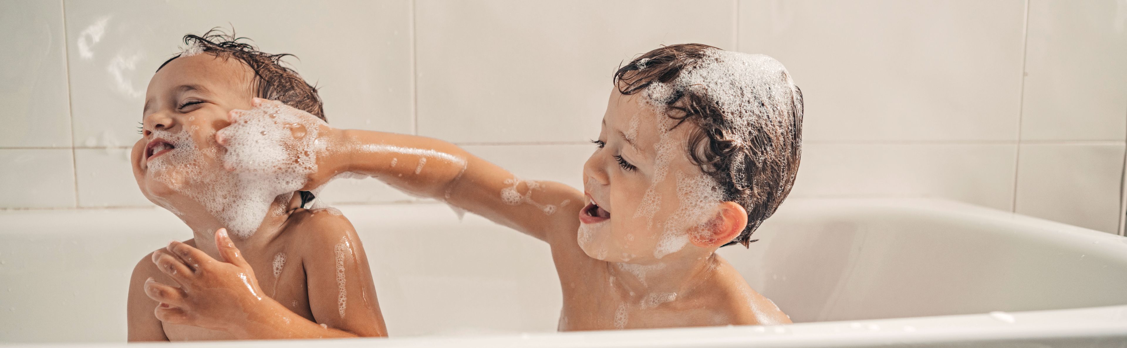 Two children enjoying a bath feel the comfort and warmth provided by water heated with photovoltaic solar energy.