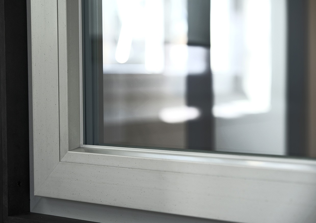 Moldura de janela branca com borda preta, exibindo um design moderno e elegante, com um painel de vidro transparente refletindo um espaço interior desfocado.