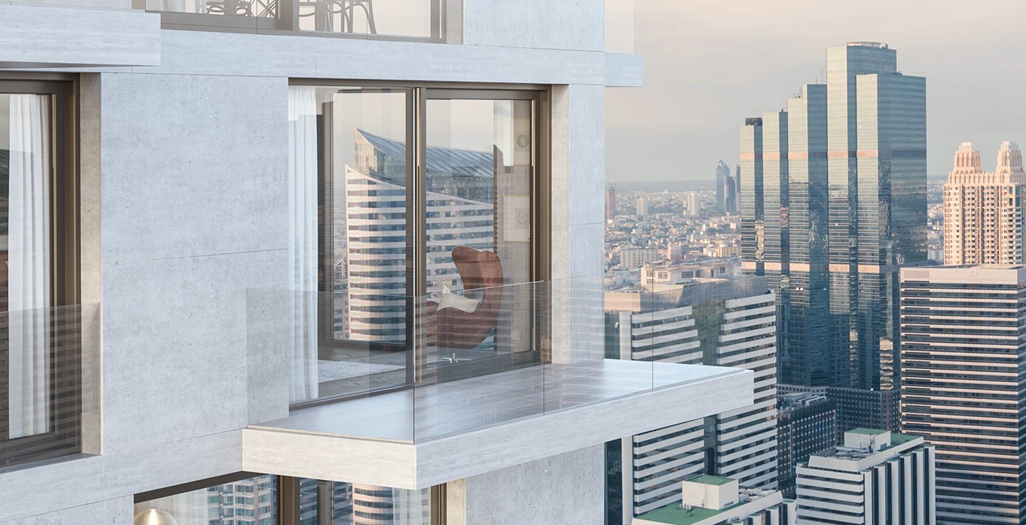 Een glazen balkon met uitzicht op de skyline van de stad, met een bruine stoel en een glazen reling.