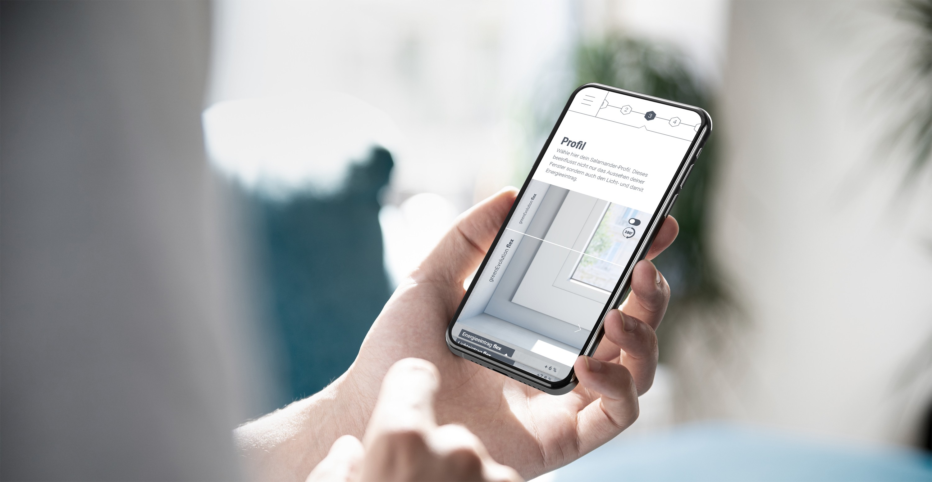 A person holding a smartphone displaying a profile page with a window and energy efficiency information.