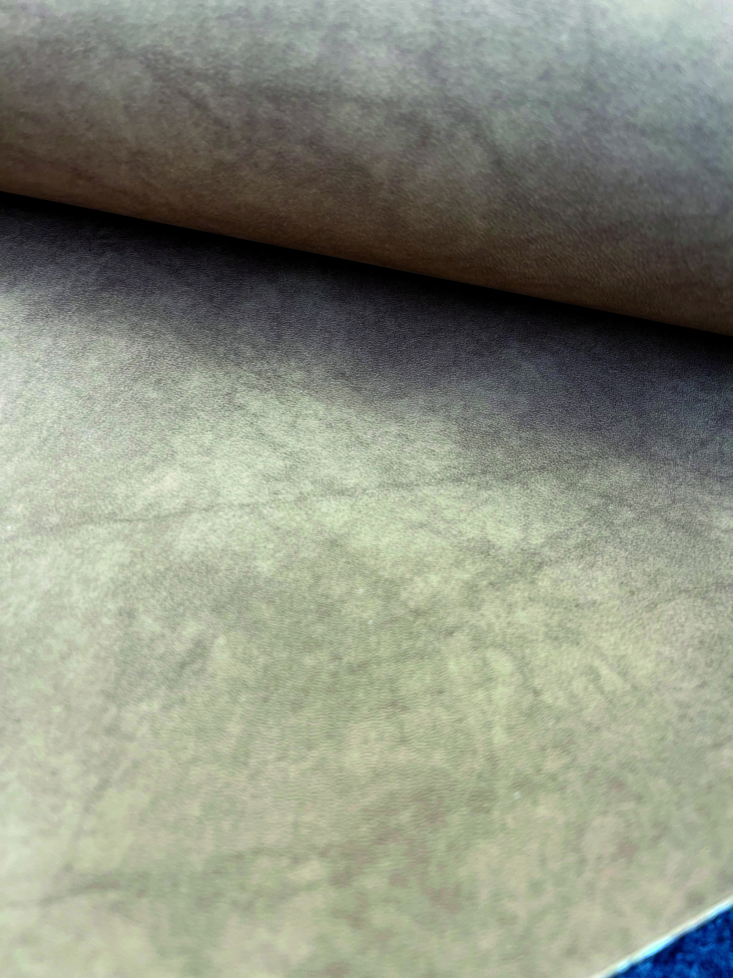 Close-up of a beige, textured fabric with a subtle pattern, possibly used for upholstery or interior design.