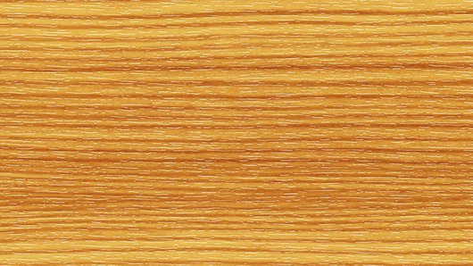 Nahaufnahme einer Holzoberfläche mit einer warmen, goldbraunen Farbe und sichtbaren Maserungsmustern.