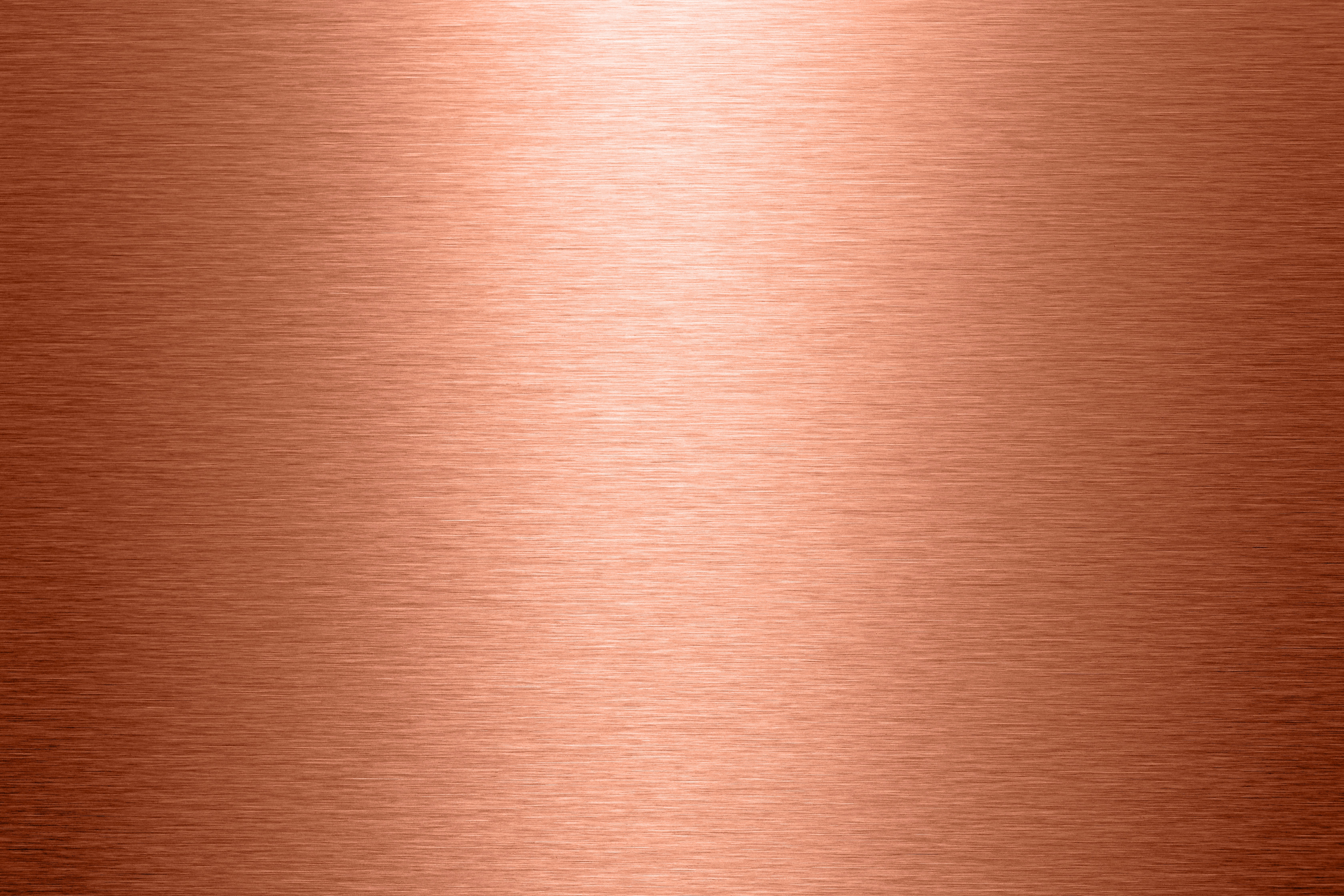 Una vista cercana de una superficie metálica brillante con un cálido tono rojizo-marrón, posiblemente cobre o una aleación a base de cobre.