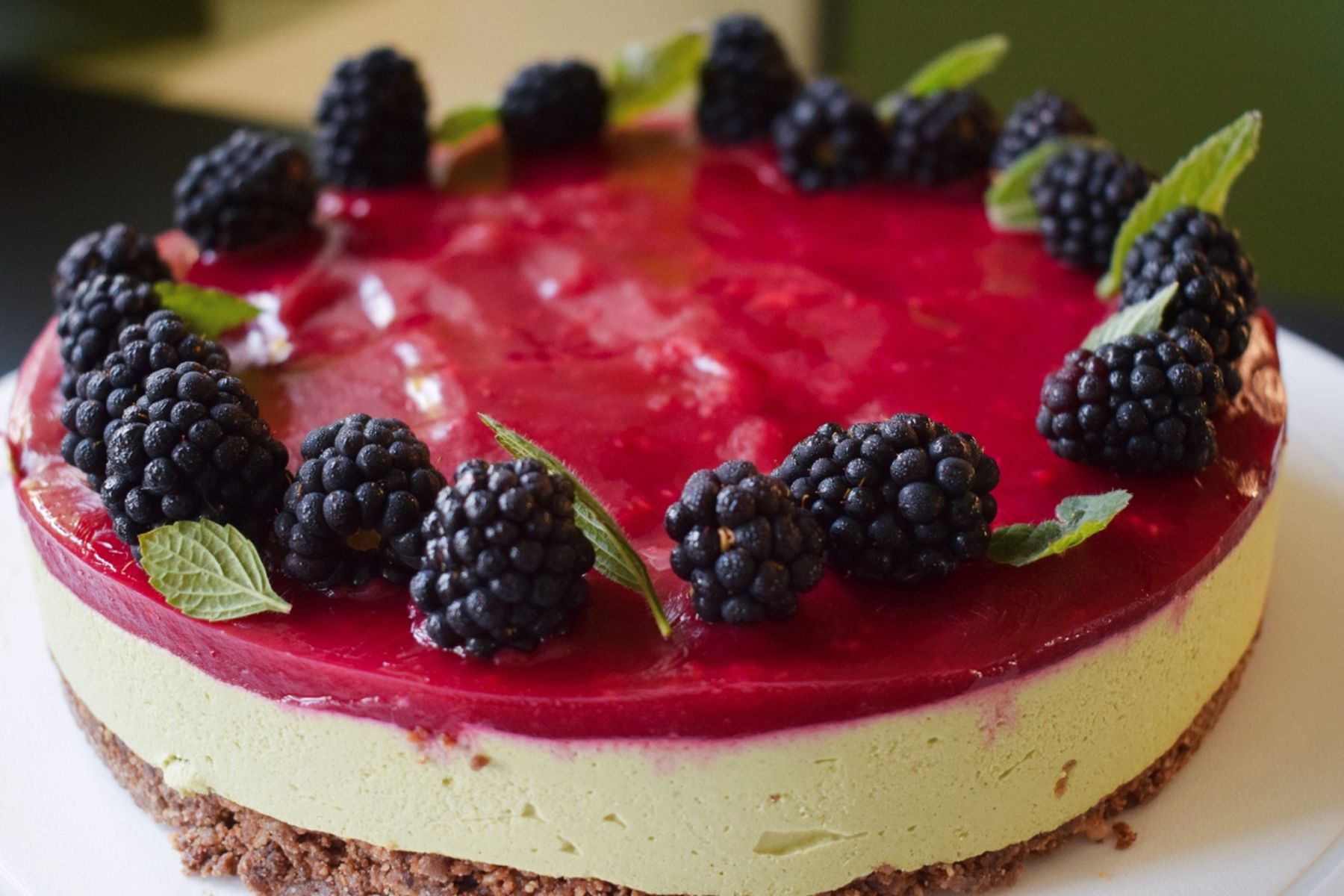 Dort s malinovou vrstvou a matcha náplní, ozdobený čerstvými ostružinami a lístky máty, na bílém talíři. Recept připravily Ségry v kuchyni.