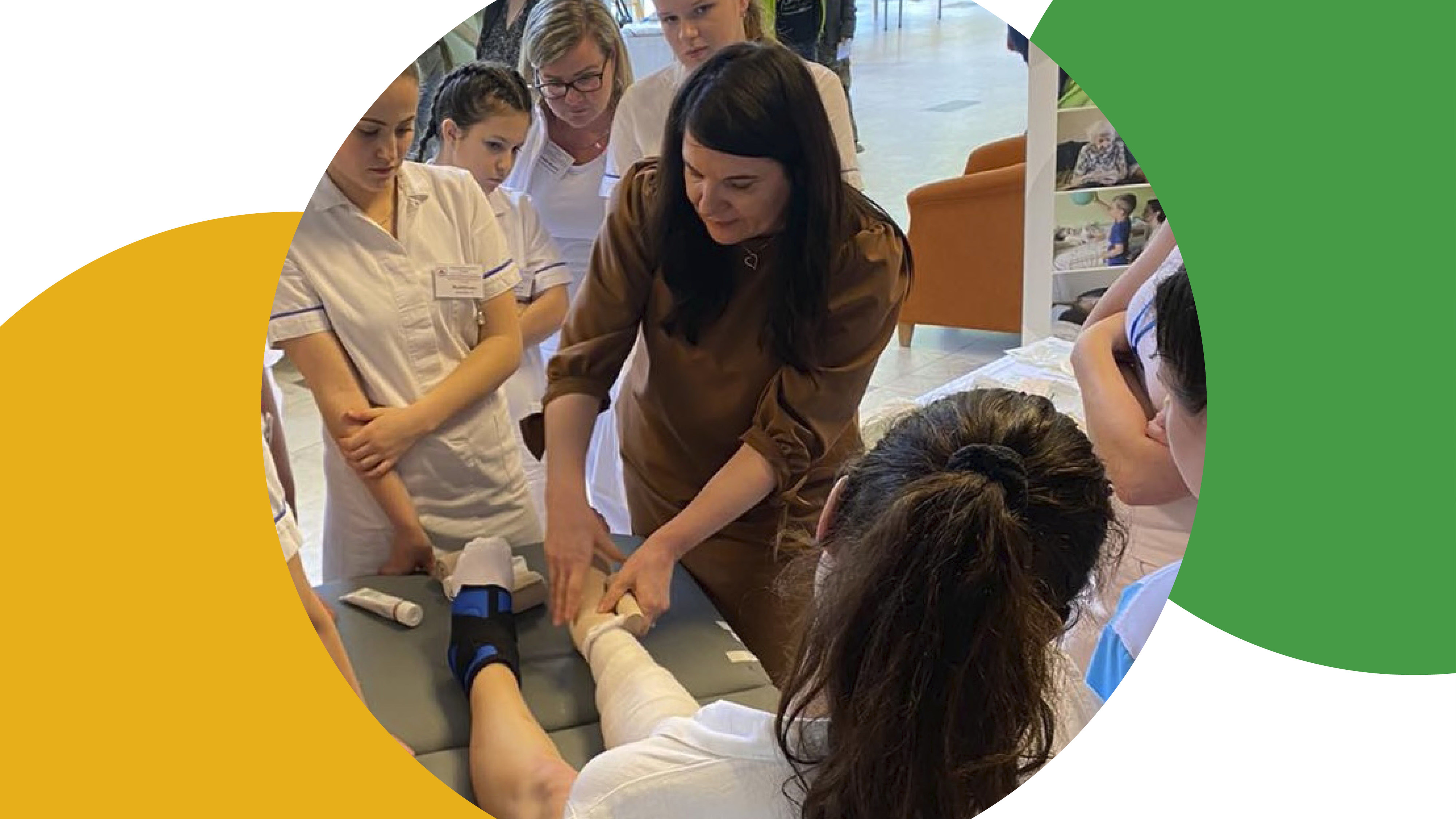 Žena předvádí, jak obvázat nohu skupině studentů medicíny v prostředí učebny.