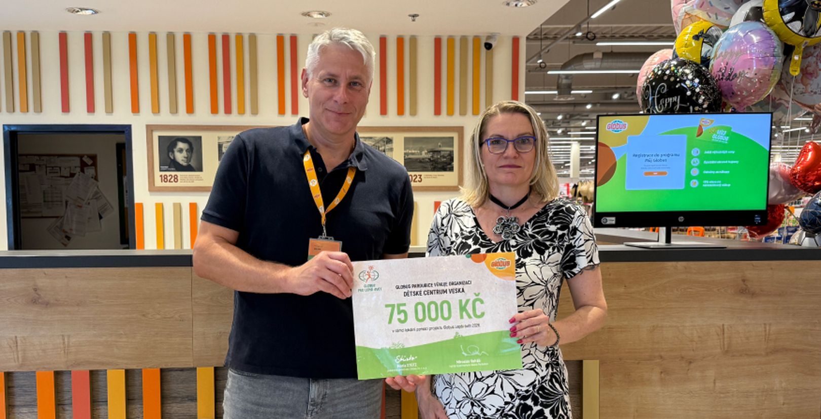 Muž a žena  s darovacím šekem na částku  150 000 Kč v hypermarketu Globus