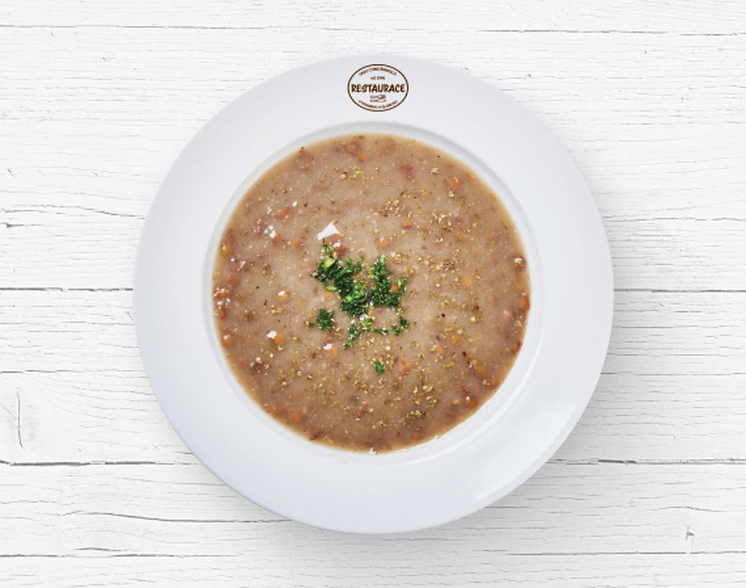 Čočková polévka na bílém talíři z Restaurace Globus