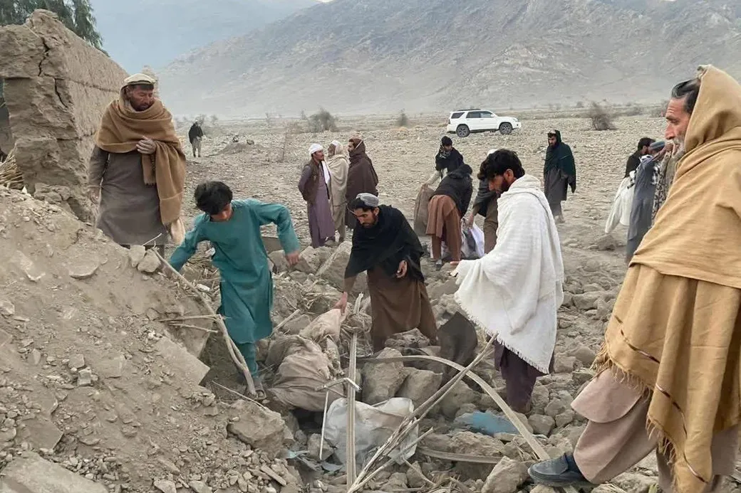 Mensen staan bij een door een bombardement vernietigde woning in Nazakat