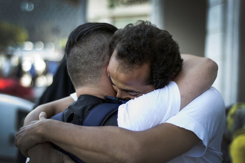 Two people sharing a heartfelt embrace outdoors, capturing an emotional moment of connection and support.