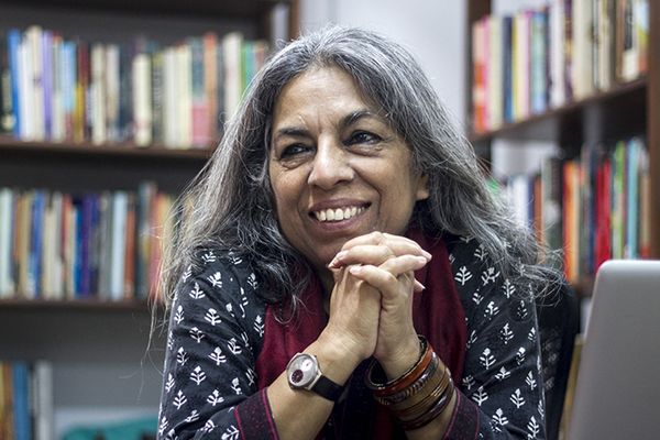 Portretbeeld van uitgeefster Urvashi Butalia voor een boekenkast