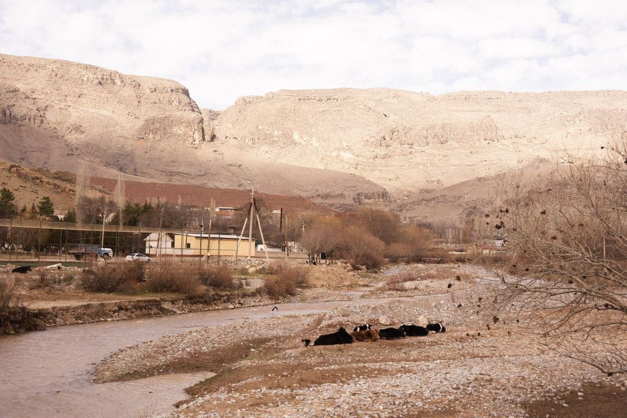 Het grensgebied tussen Afghanistan en Oezbekistan, met de Amu Darja-rivier en droge heuvels op de achtergrond.