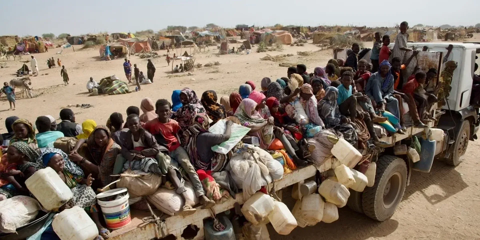 Soedanese vluchtelingen zitten opeengepakt op de lader van een vrachtwagen
