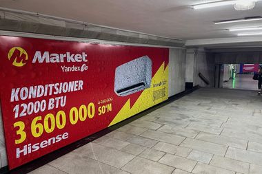 Advertisement for 12,000 BTU Hisense air conditioner priced at 3,600,000 So'm, displayed in an underground passage.