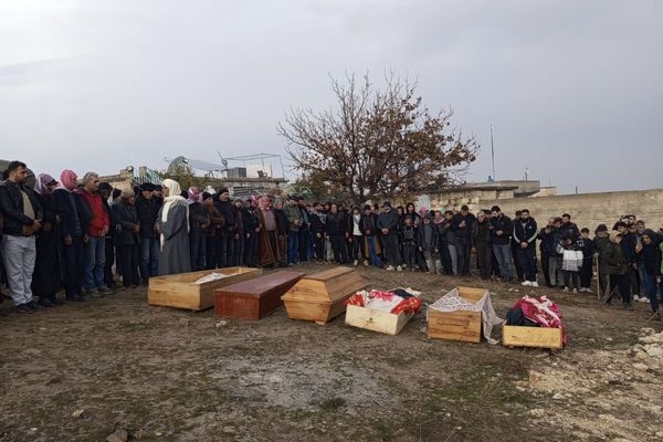 Zeven doodskisten op een veld in een dorp