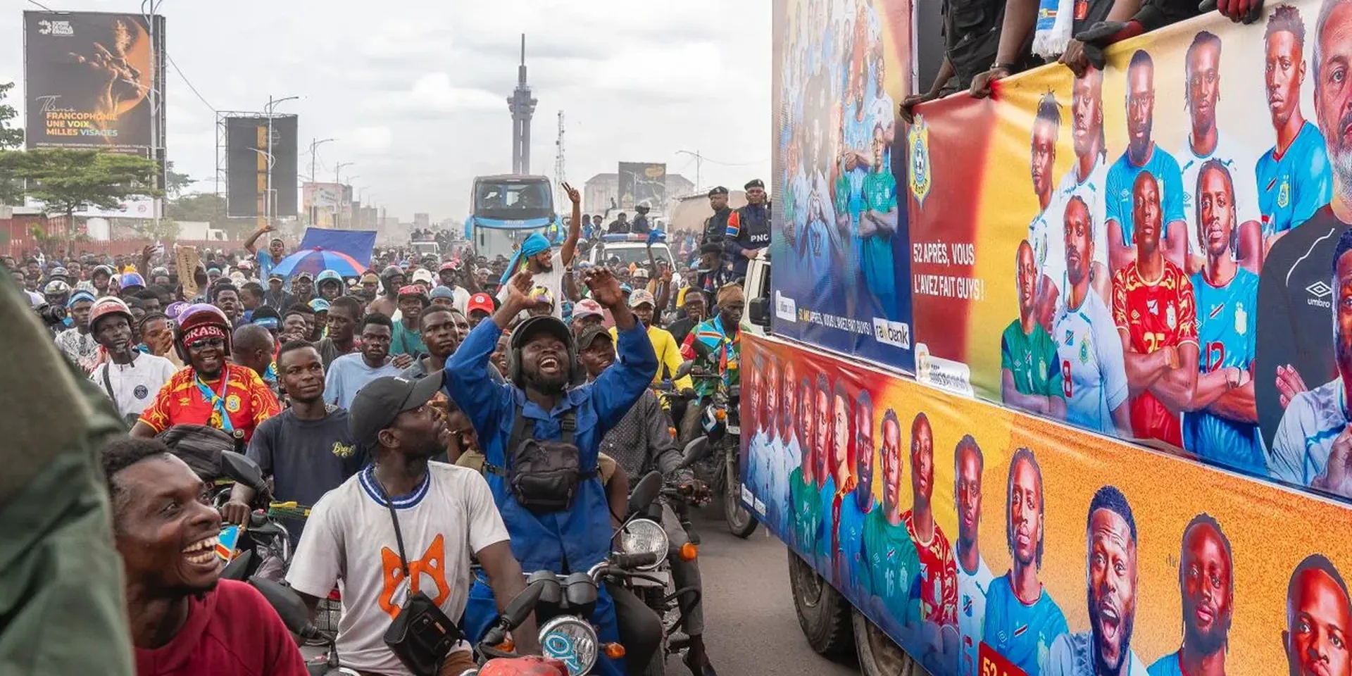 Supporters van de Congolese nationale ploeg kijken naar een bus