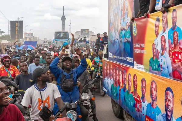 Supporters van de Congolese nationale ploeg kijken naar een bus