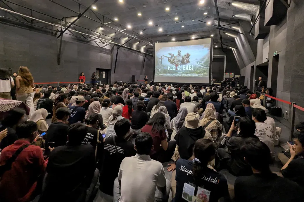 Een volle zaal kijkt naar de documentaire Pesta Babi