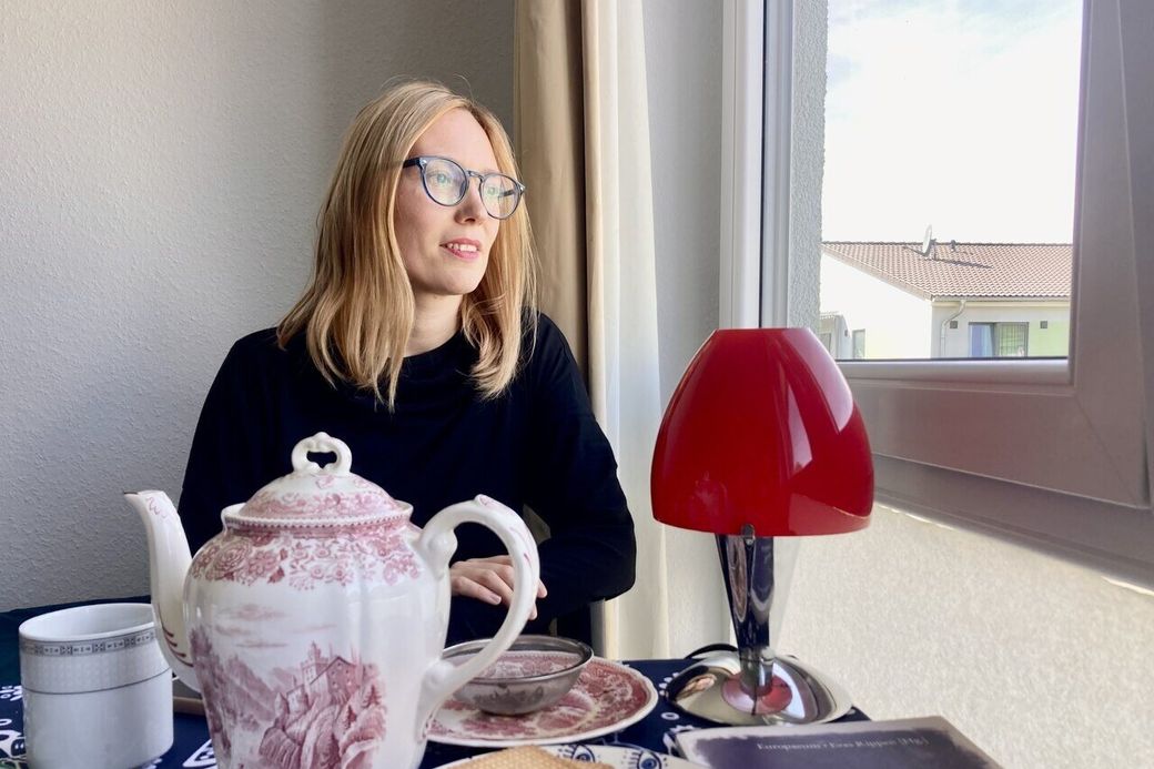 een vrouw staart uit het raam