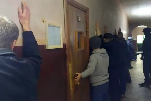 Arrestanten van de Oekraïense veiligheidsdiensten staan met de armen gespreid tegen een muur