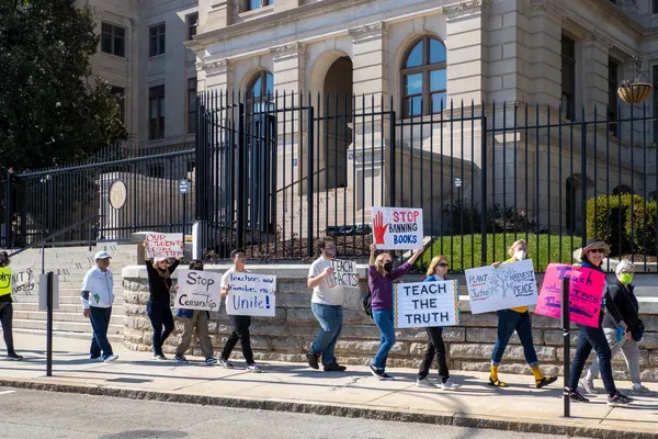 mensen protesteren op een voetpad met pancartes in de hand tegen censuur en het verbannen van boeken uit scholen