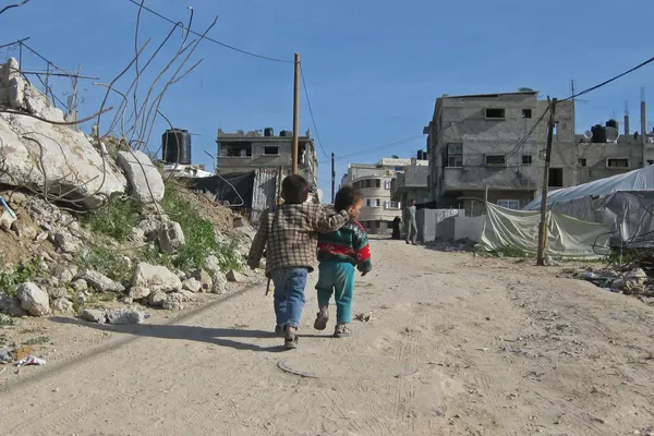 Twee palestijnse kinderen wandelen weg van de camera