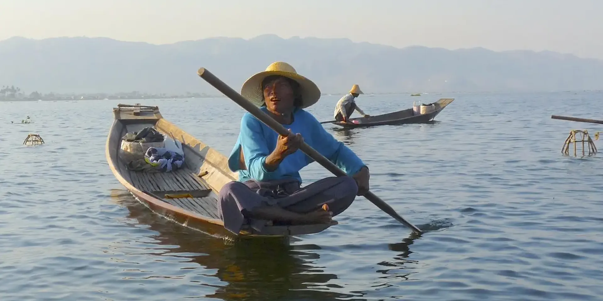 locale vissers in een kano tussen uit riet gevlochten visfuiken