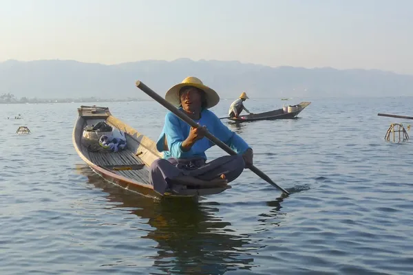 locale vissers in een kano tussen uit riet gevlochten visfuiken
