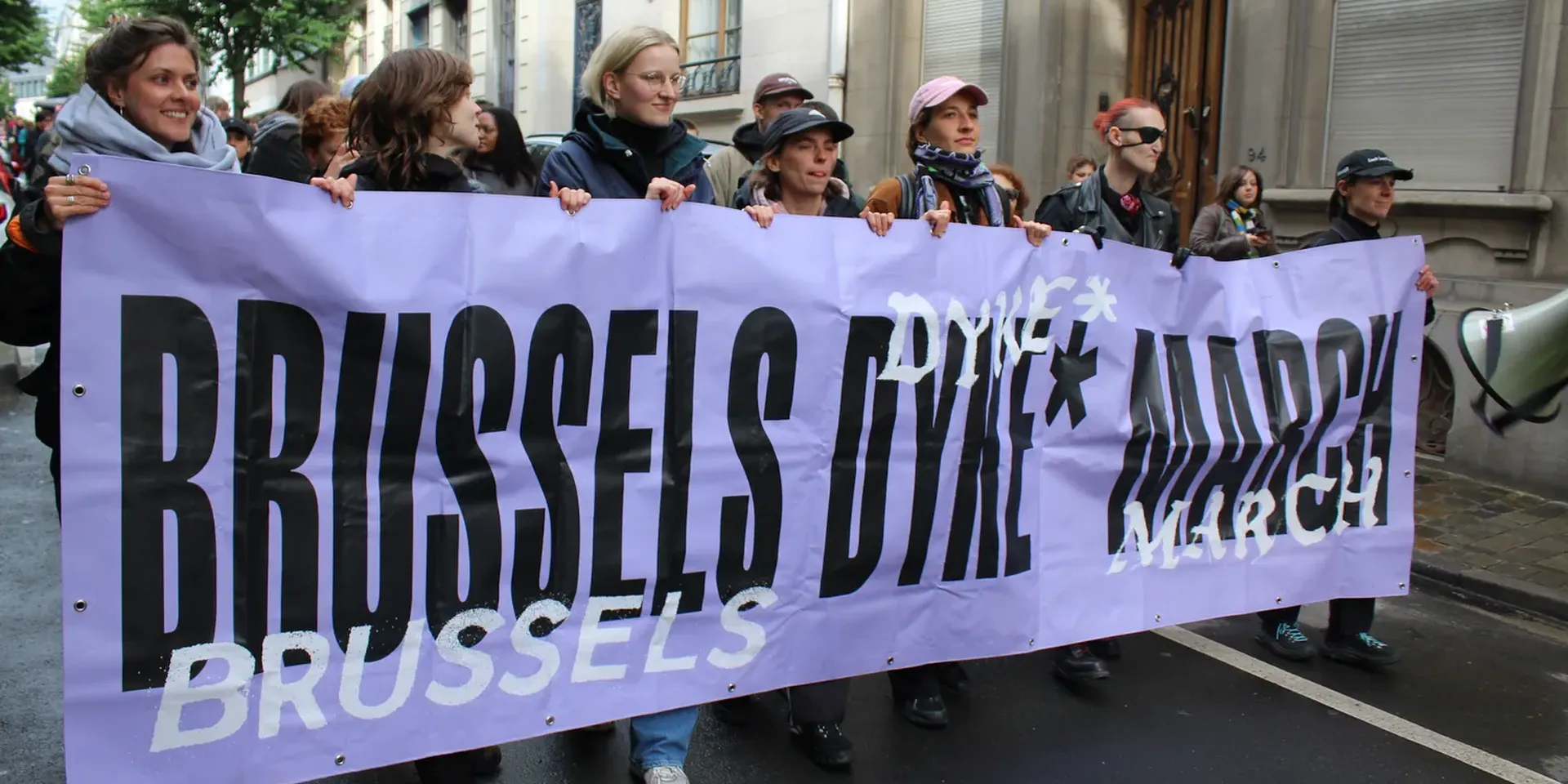 vrouwezn houden een banner vast met de tekst ‘Brussels Dyke* March’