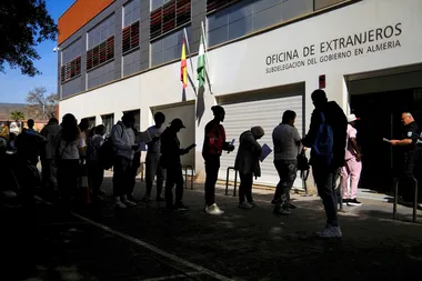 mensen schuiven aan bij een migratiekantoor in Almeria, Spanje