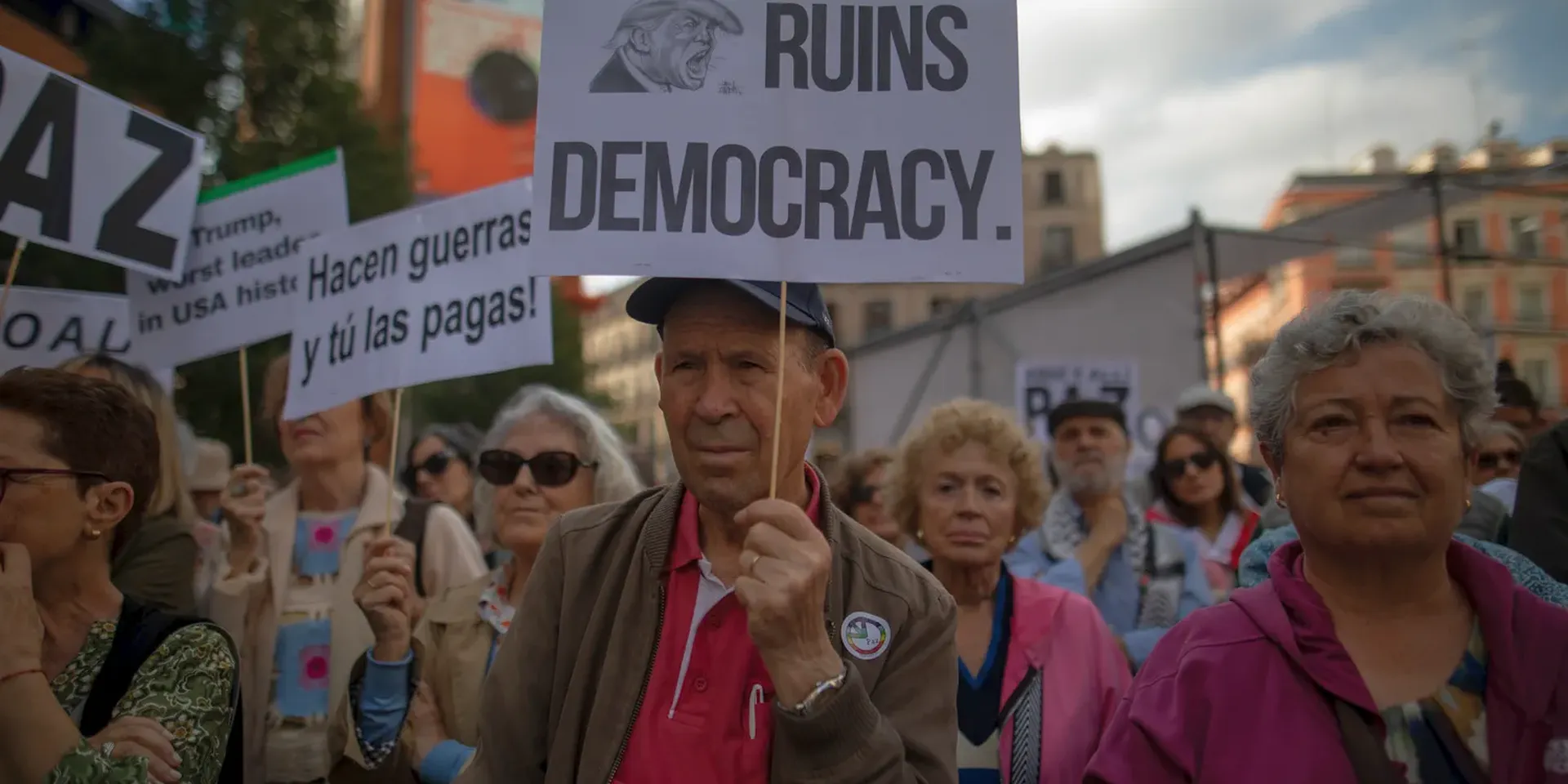 Betoging van Spanjaarden met pancartes die de Amerikaanse president Trump ervan beschuldigen de democratie te ruïneren