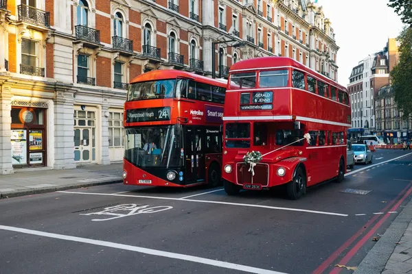 Een nieuwe elektrische en een oude dubbeldekbus in Londen