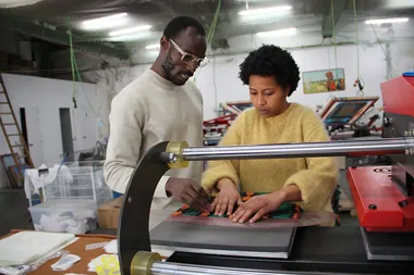 Twee personen aan een naaimachine in een Barcelonees atelier