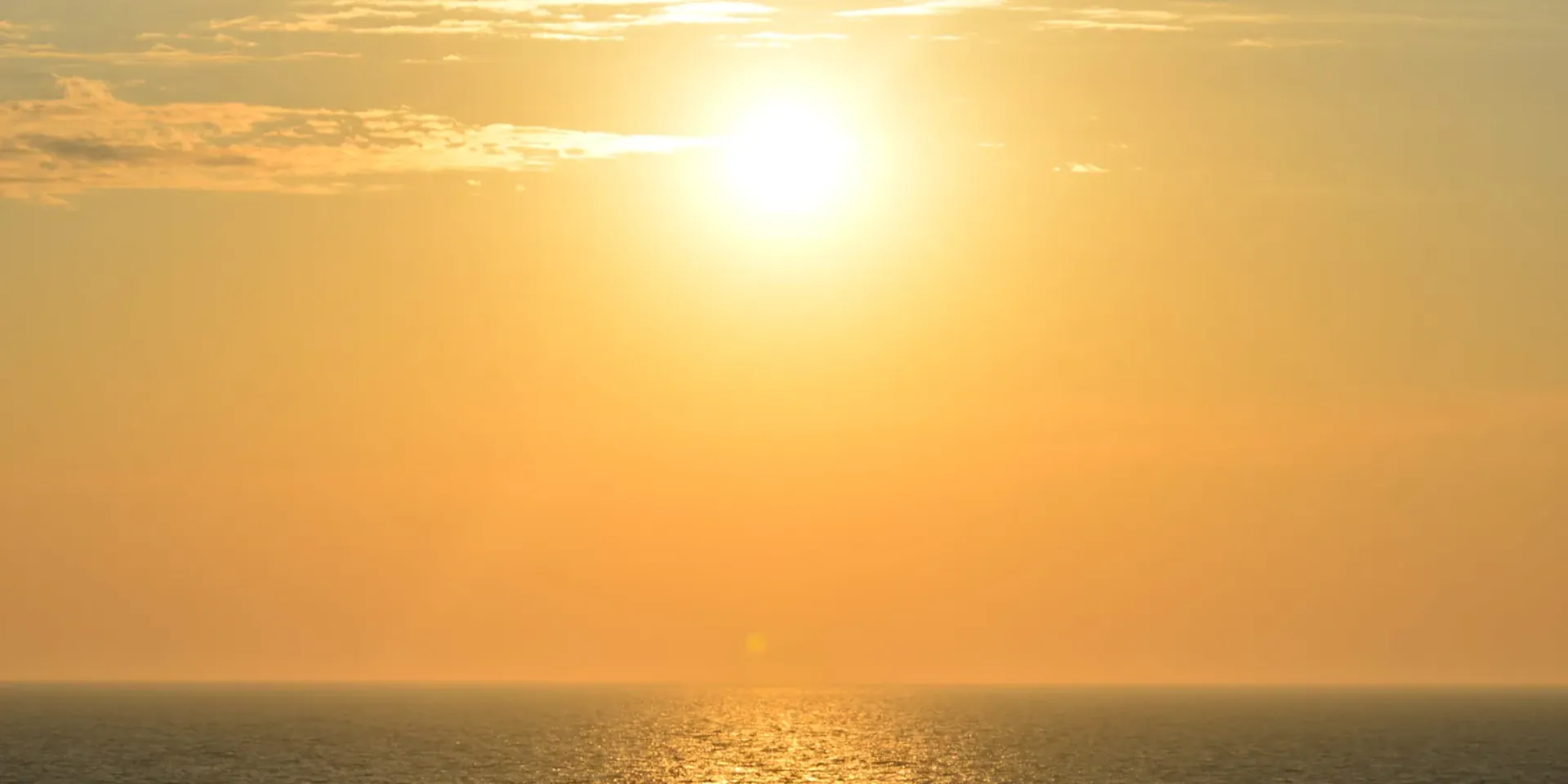 een verzengende zon boven de uitgestrekte zee