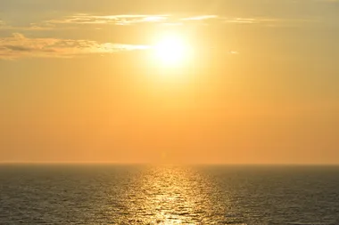 een verzengende zon boven de uitgestrekte zee