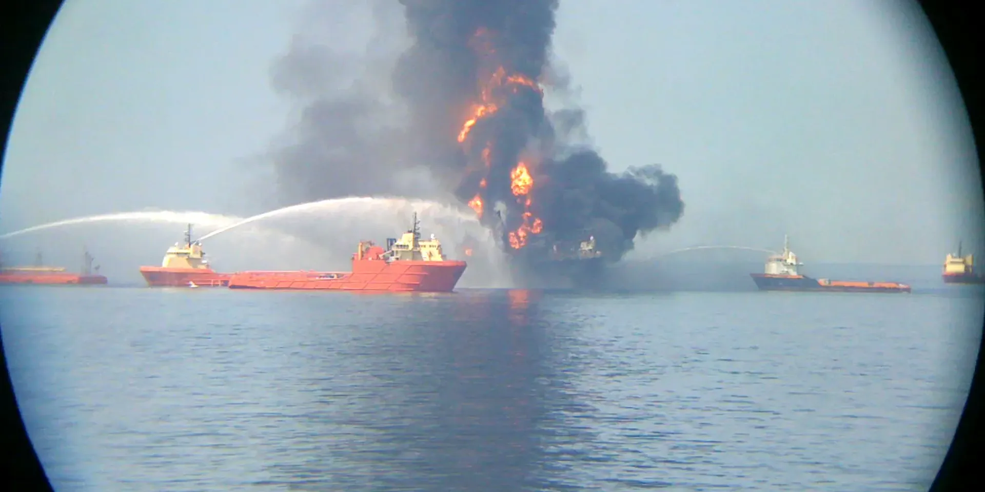 Blusvaartuigen doen verwoede pogingen om de brand op het olieplatform Deepwater Horizon te doven.