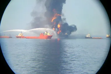 Blusvaartuigen doen verwoede pogingen om de brand op het olieplatform Deepwater Horizon te doven.