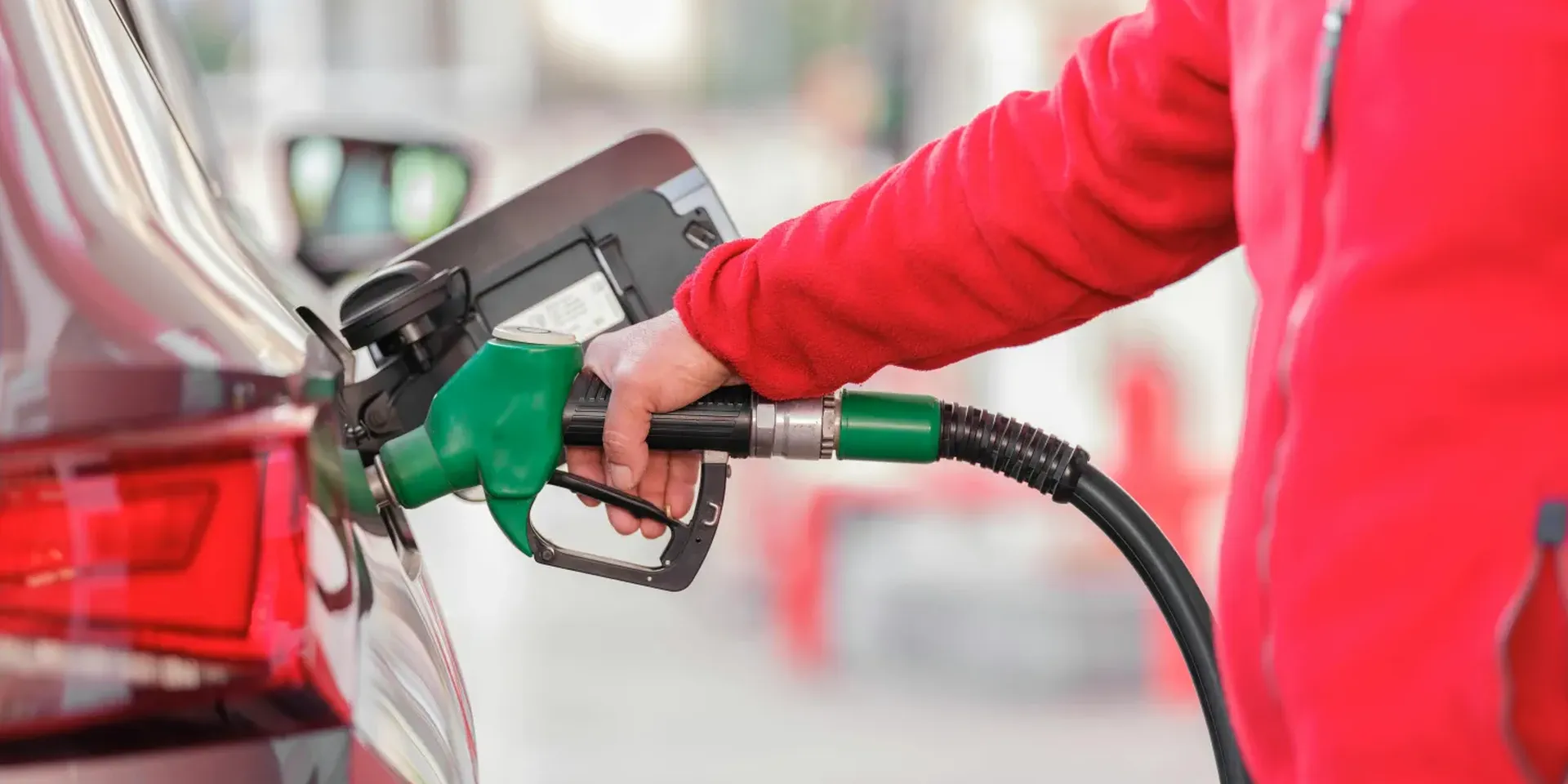 detal van een man die zijn wagen voltankt