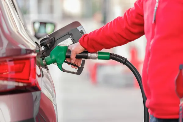 detal van een man die zijn wagen voltankt