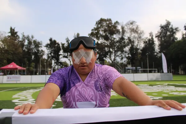 Een met pleisters geblinddoekte voetbalster staat aan de zijkant van een voetbalveld