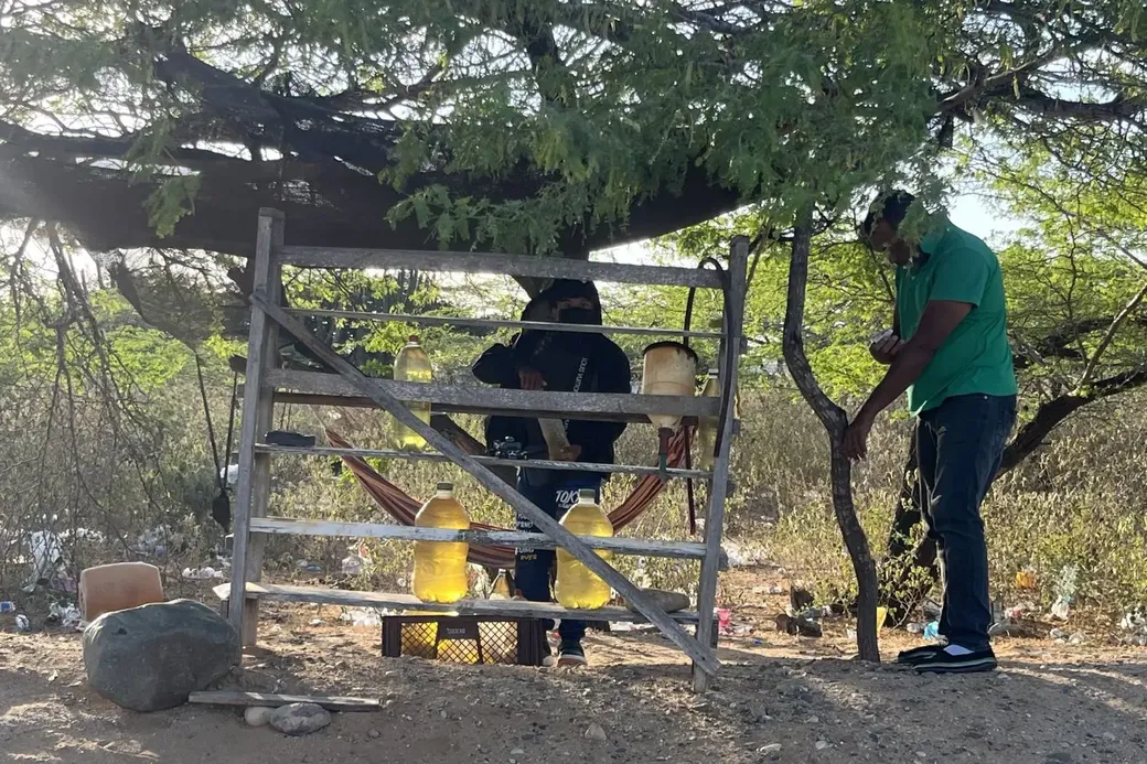 Een infirmeel tankstation: een man verkoopt benzine in grote waterflessen