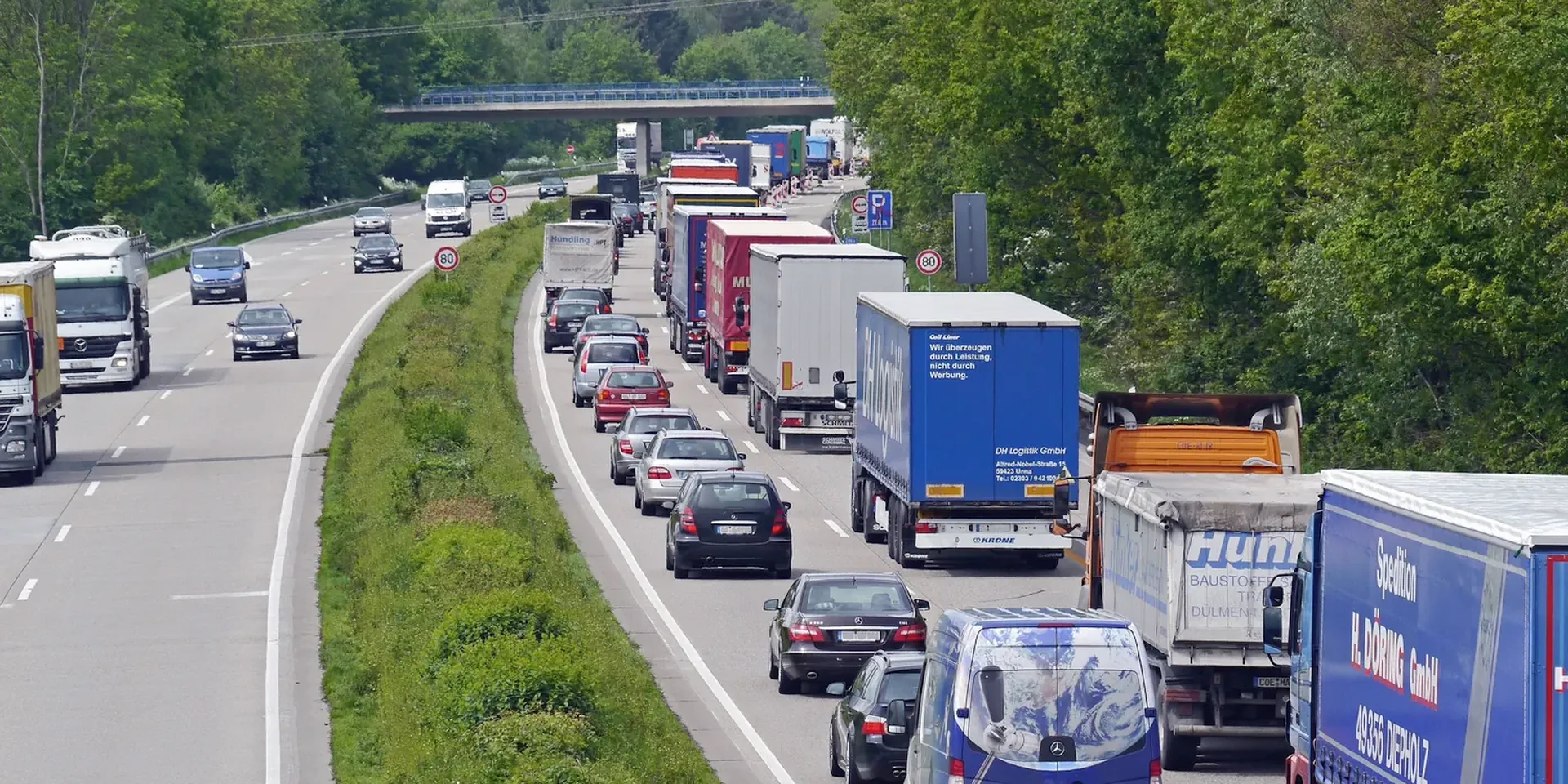 vrachtwagens en personenwagens staan in een file op een snelweg