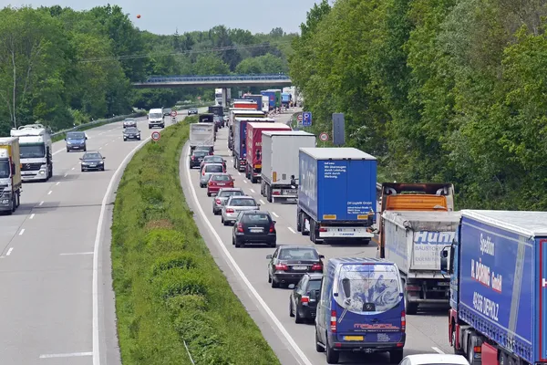 vrachtwagens en personenwagens staan in een file op een snelweg