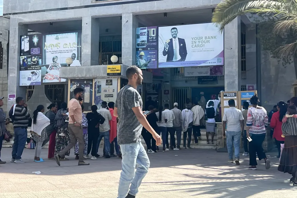 Een lange rij mensen schuift aan bij een bank om geld af te halen
